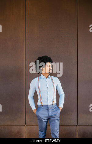 Der bärtige Mann mit Hemd und Hosenträgern vor der rostigen Hintergrund stehend Stockfoto