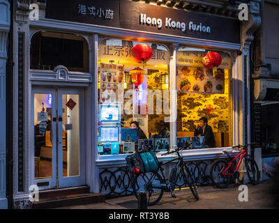Deliveroo Lebensmittel-lieferservice Kuriere holen Sie Mahlzeiten zum Mitnehmen aus dem Hong Kong Fusion Restaurant im Zentrum von Cambridge Großbritannien Stockfoto