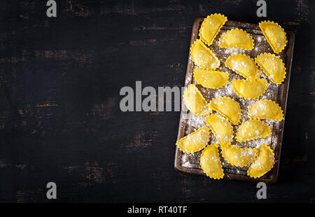 Ungekocht ravioli auf Tisch. Italienische Küche. Ansicht von oben Stockfoto