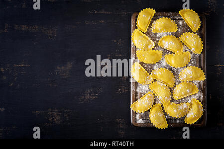 Ungekocht ravioli auf Tisch. Italienische Küche. Ansicht von oben Stockfoto