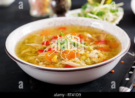 Suppe mit Linsen, Karotten, Hähnchenfleisch, Paprika, Sellerie in eine Schüssel geben. Stockfoto