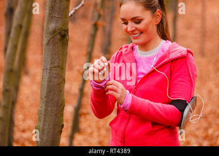 Gesunder Lebensstil Konzept. Portrait von attraktiven sportlichen lächelnde Mädchen tragen sportliche Kleidung. Frau bereiten sich auf die Ausübung im herbstlichen Wald. Stockfoto