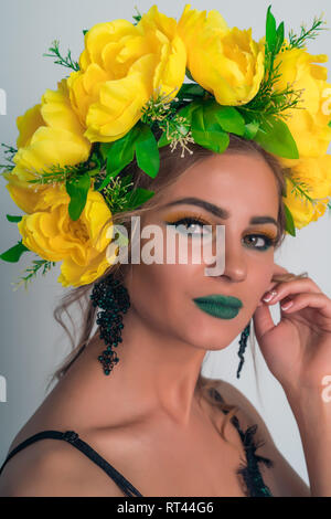 Porträt einer schönen Blondine mit hellen, Make-up und eine Felge von gelben Blumen Stockfoto