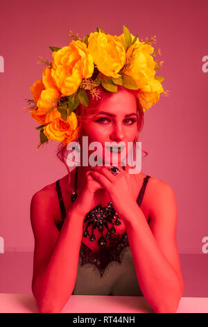 Modische Portrait von einem schönen Mädchen mit einem Kranz von Blumen und helles Make-up. Farbfilter Stockfoto