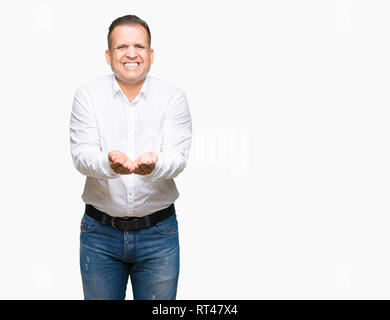 Mittleren Alter arabischen eleganten Mann über isolierte Hintergrund lächelnd mit Hände Handflächen geben oder empfangen Geste. Halt und Schutz Stockfoto