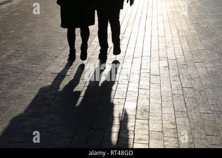 Die Menschen auf der Straße, schwarze Silhouetten und Schatten auf Fußgänger Gehweg. Konzept der Stadt leben, die Fremden, dramatischer Geschichten Stockfoto