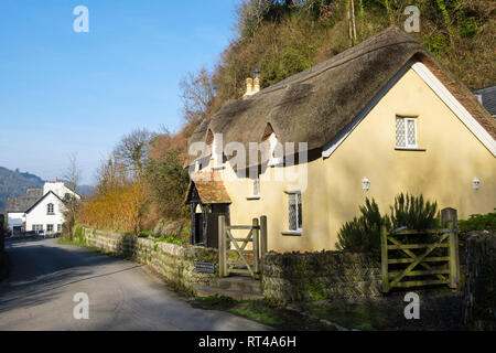 17. jahrhundert alten Zimmermädchen Cottage mit einem traditionellen Reetdach und Blick hinunter Lane, um alte Post in im hübschen Dorf Lee North Devon England Großbritannien Stockfoto