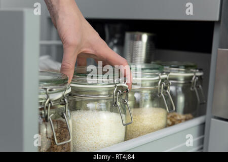 Frauen Kommissionierung ein Element aus dem Stall. Smart Küche Organisation Konzept Stockfoto