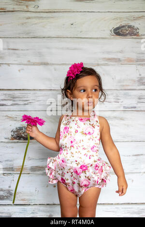 Ausschreibung lächelnd Kleinkind, mit einer Blume in der Hand. Stockfoto