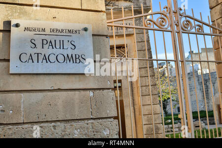 Die geschlossene Eingangstor mit Zeichen für die St. Pauls Katakomben und Museum auf eine sandsteinmauer. Rabat. Malta. Europa. Stockfoto