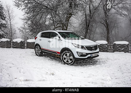 Kia Sportage 2.0 CRDI Awd oder 4x4, Farbe weiß, in einem Wald Straße, bedeckt mit Schnee und Eis. Extreme Bedingungen und Temperaturen unter -10 Stockfoto