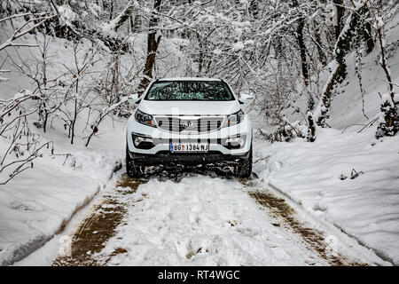 Kia Sportage 2.0 CRDI Awd oder 4x4, Farbe weiß, in einem Wald Straße, bedeckt mit Schnee und Eis. Extreme Bedingungen und Temperaturen unter -10 Stockfoto