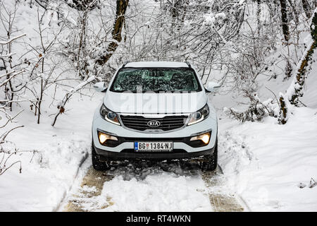 Kia Sportage 2.0 CRDI Awd oder 4x4, Farbe weiß, in einem Wald Straße, bedeckt mit Schnee und Eis. Extreme Bedingungen und Temperaturen unter -10 Stockfoto