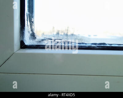 PVC-Fenster sind alt, gebrochen. auf dem Eis Glas im Zimmer. Stockfoto