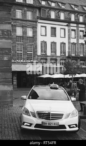 Straßburg, Frankreich - 21.September 2014: Schwarz-Weiß-Bild von Mercedes-Benz E-Klasse Taxi an einem regnerischen Tag im Zentrum von Straßburg, Place Kleber neben Cafe Stockfoto