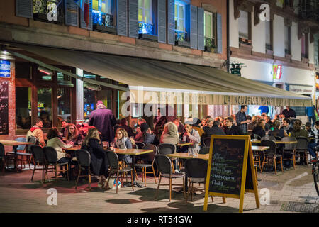 Straßburg, Frankreich - 31.Oktober 2017: Kunden Essen ausserhalb drinkiing auf einer kalten Nacht im La Nouvelle poste Cafe Bar Terrasse in Straßburg, Frankreich Stockfoto