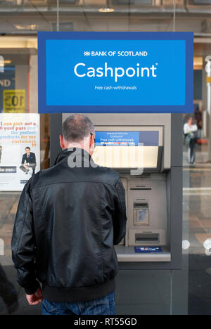 Mann bei der ATM Bank of Scotland in der Argyle Street, 'S St. Enoch', Glasgow, Schottland, Großbritannien Stockfoto