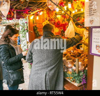 COLMAR, Frankreich - 23.November 2015: Paar kaufen Spezialitäten auf dem Weihnachtsmarkt in der französischen Stadt Stall-traditionelle Speisen und Geschenke Stockfoto