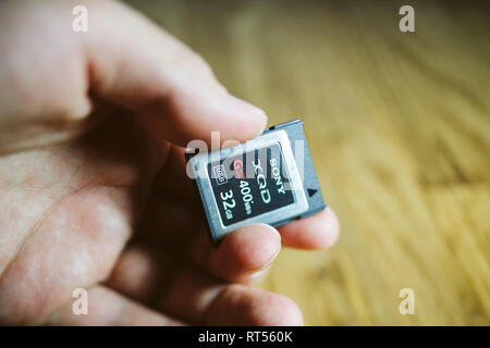 PARIS, Frankreich, 26.MÄRZ 2017: Mann hält Neue XQD Daten Speicherkarte von Sony 128 GB XQD Serie G Speicherkarte in Nikon und Sony video foto Produkte für die Speicherung von Inhalten verwendet werden Stockfoto