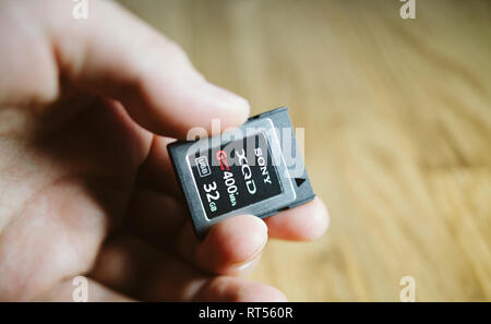 PARIS, Frankreich, 26.MÄRZ 2017: Mann hält Neue XQD Daten Speicherkarte von Sony 128 GB XQD Serie G Speicherkarte in Nikon und Sony video foto Produkte für die Speicherung von Inhalten verwendet werden Stockfoto