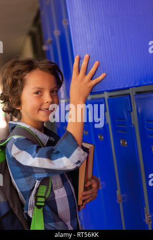 Schüler herauf Bücher aus dem Spind in der Umkleide Stockfoto