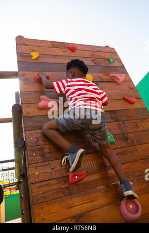 Schüler Klettern an einer Wand in der Schule Spielplatz Stockfoto