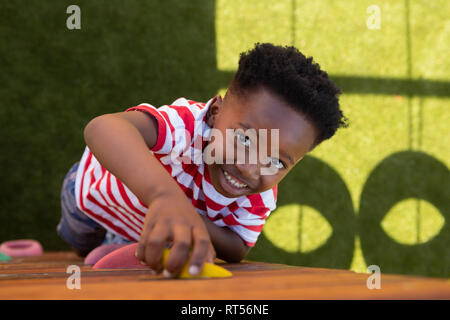 Schüler Klettern an einer Wand in der Schule Spielplatz Stockfoto