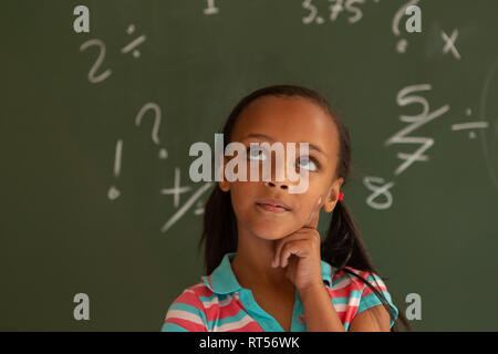 Die Schülerin gegen grüne Board in einem Klassenzimmer in der Schule Stockfoto