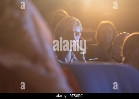 Geschäftsfrau sitzen und hören auf die Präsentation mit Konzentration im Auditorium Stockfoto