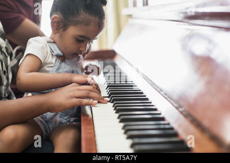 Neugierig toddler girl Klavier spielen Stockfoto