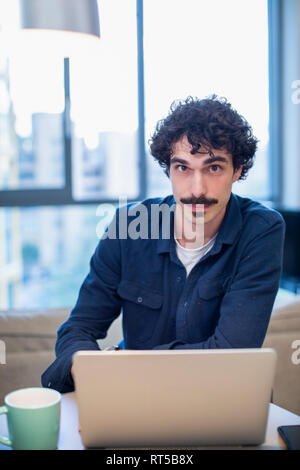 Portrait zuversichtlich Mann am Laptop arbeiten Stockfoto