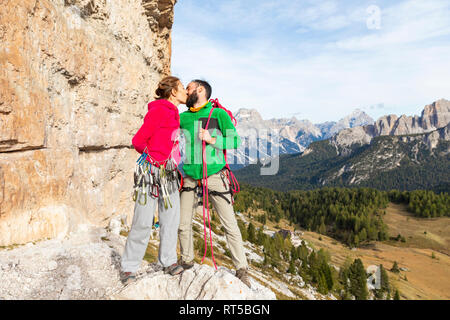 Italien, Cortina d'Ampezzo, Paar mit Klettersteigausrüstung in den Dolomiten küssen Stockfoto