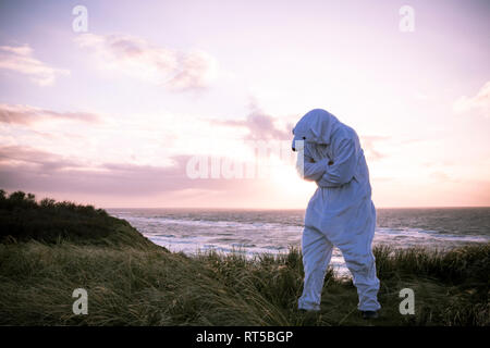 Dänemark, Nordjuetland, Mann, der Eisbär Kostüm am Strand Stockfoto