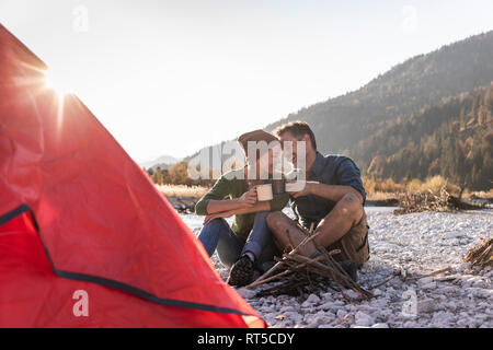 Reifes Paar camping am Flußufer im Abendlicht Stockfoto