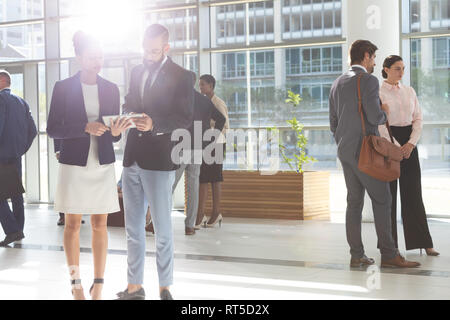 Diverse Geschäftsleute suchen und diskutieren über digitale Tablet-PC in der Lobby Büro Stockfoto