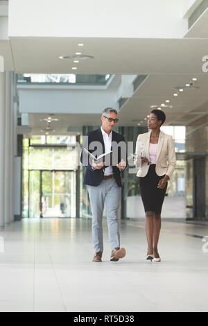 Diverse Geschäftsleute interagieren beim Gehen in der Lobby Büro Stockfoto