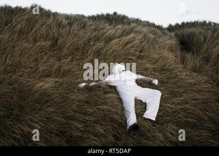 Dänemark, Nordjuetland, Mann, der Eisbär Kostüm im Gras liegend Stockfoto