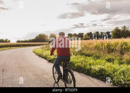 Ältere Menschen Reiten Fahrrad auf Feldweg Stockfoto