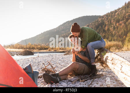 Reifes Paar camping am Flußufer im Abendlicht Stockfoto