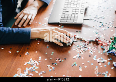 Hand einer Frau auf einem Schreibtisch voller Konfetti arbeiten Stockfoto