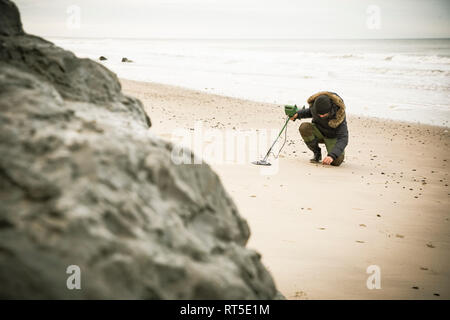 Mann mit Metalldetektor am Sandstrand Stockfoto