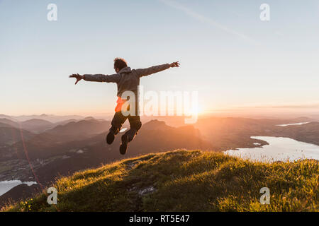 Österreich, Salzkammergut, Wanderer auf Berge Gipfel vor Freude hüpfend Stockfoto