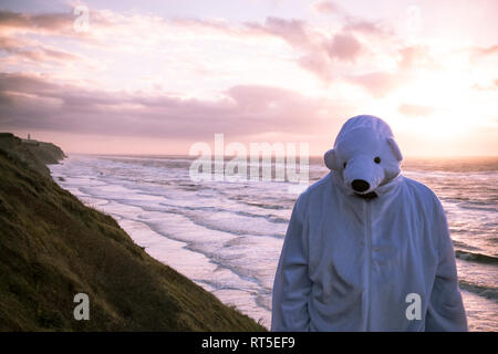 Dänemark, Nordjuetland, Mann, der Eisbär Kostüm am Strand Stockfoto