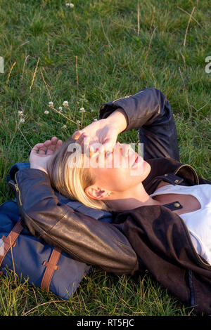 Frau liegt auf einer Wiese in einem Park entspannen Stockfoto