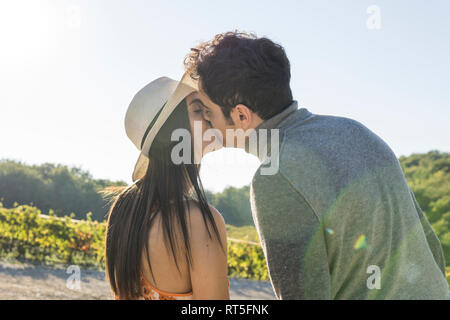 Italien, Toskana, Siena, junges Paar Küssen in einem Weinberg Stockfoto