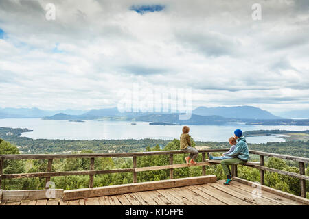 Chile, Puren, El Melado Nationalpark, Frau mit zwei Söhne sitzen auf der Aussichtsterrasse mit Blick auf den See Stockfoto