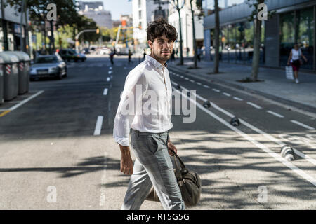 Junge Mann in der Stadt an der Kreuzung der Straße gehen Stockfoto