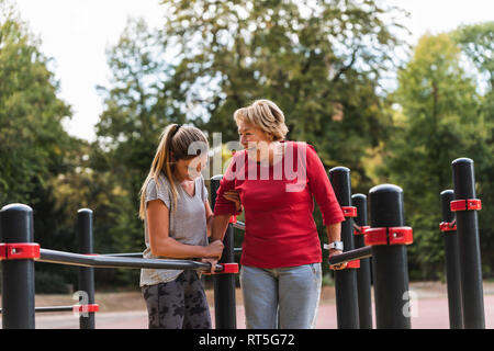 Großmutter und Enkelin Ausbildung auf dem Balken in einem Park Stockfoto