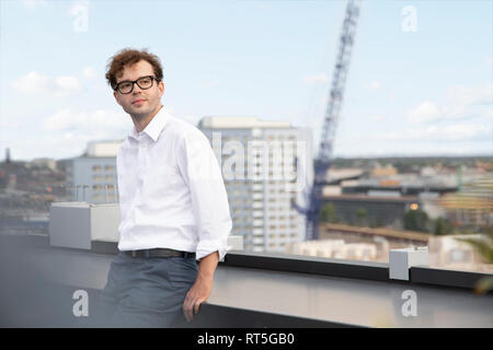 Deutschland, Berlin, Porträt Inhalt Geschäftsmann auf der Dachterrasse Stockfoto