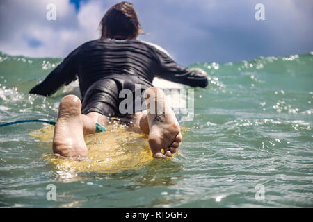 Indonesien, Bali, Kuta, Surfer liegen auf Surfbrett, Tattoo auf der Fußsohle Stockfoto